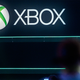 An Xbox logo hangs overhead at a trade event.